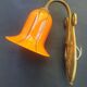 Art Deco wall light in brass with an orange globe.