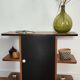 Compact bar cabinet with a pivoting door in black wood.