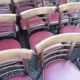 Set of 19 vintage wooden bistro chairs with red faux leather.