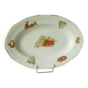 Shallow oval dish in earthenware decorated with seasonal vegetables.