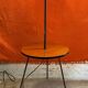 Vintage 1960s floor lamp with black tripod base and round varnished wooden shelf