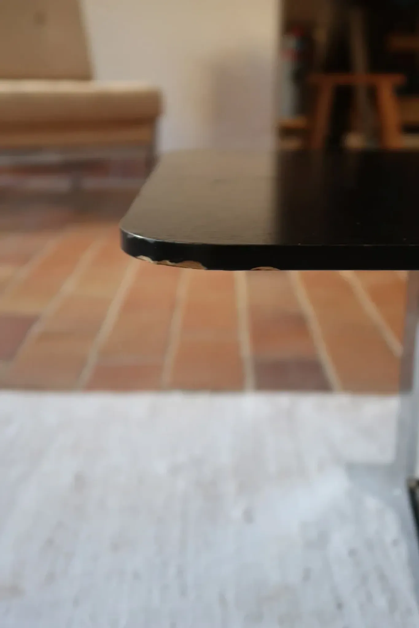 70s design coffee table with a black top and steel legs.
