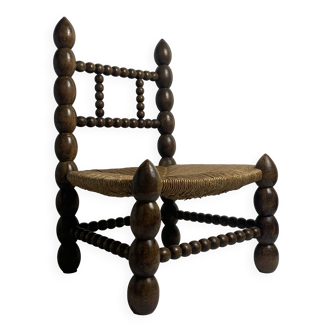 Brutalist wood turned bobbin low rush chair in the style of Charles Dudouyt