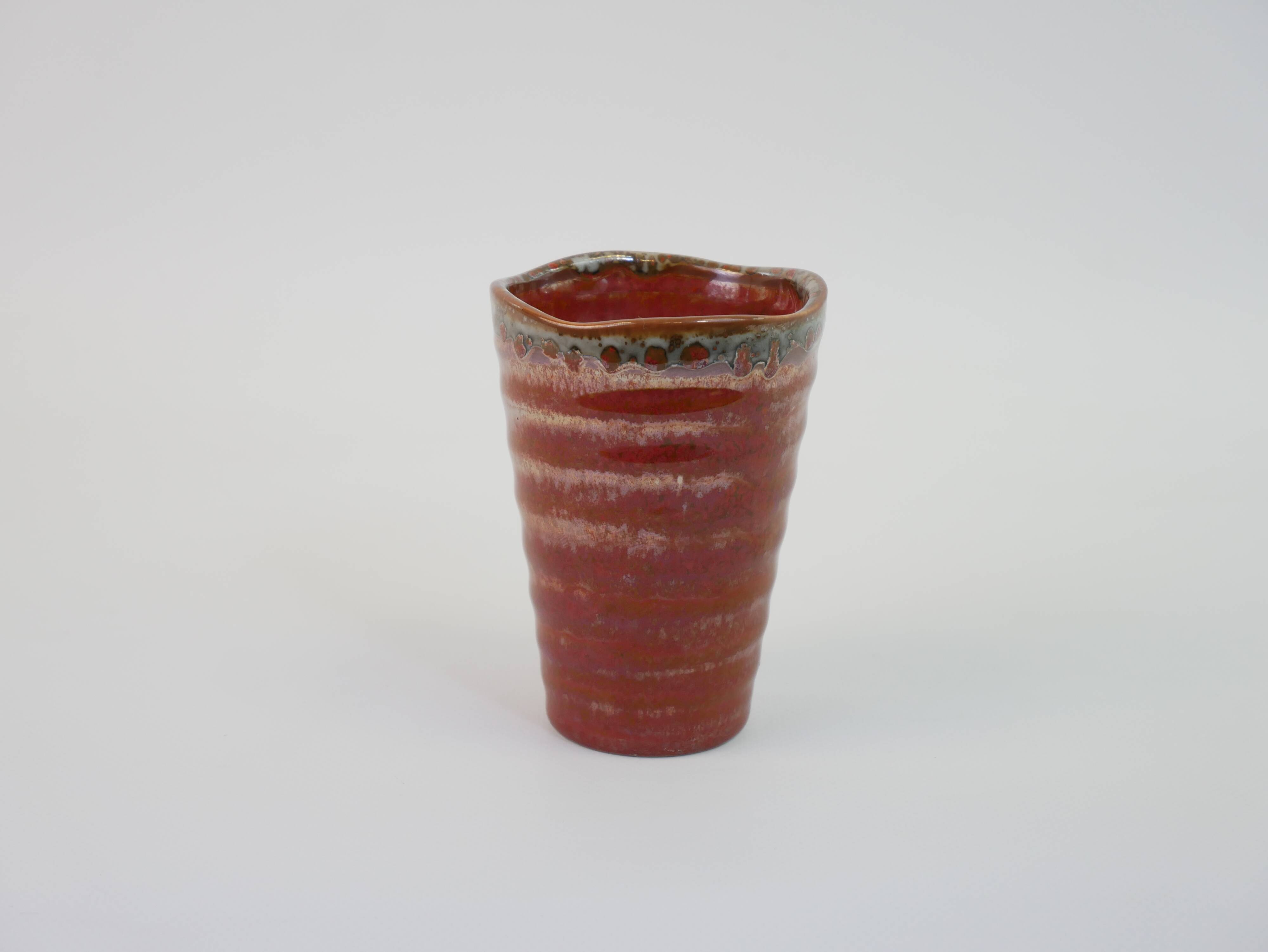 Small orange glazed ceramic cup