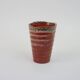 Small orange glazed ceramic cup