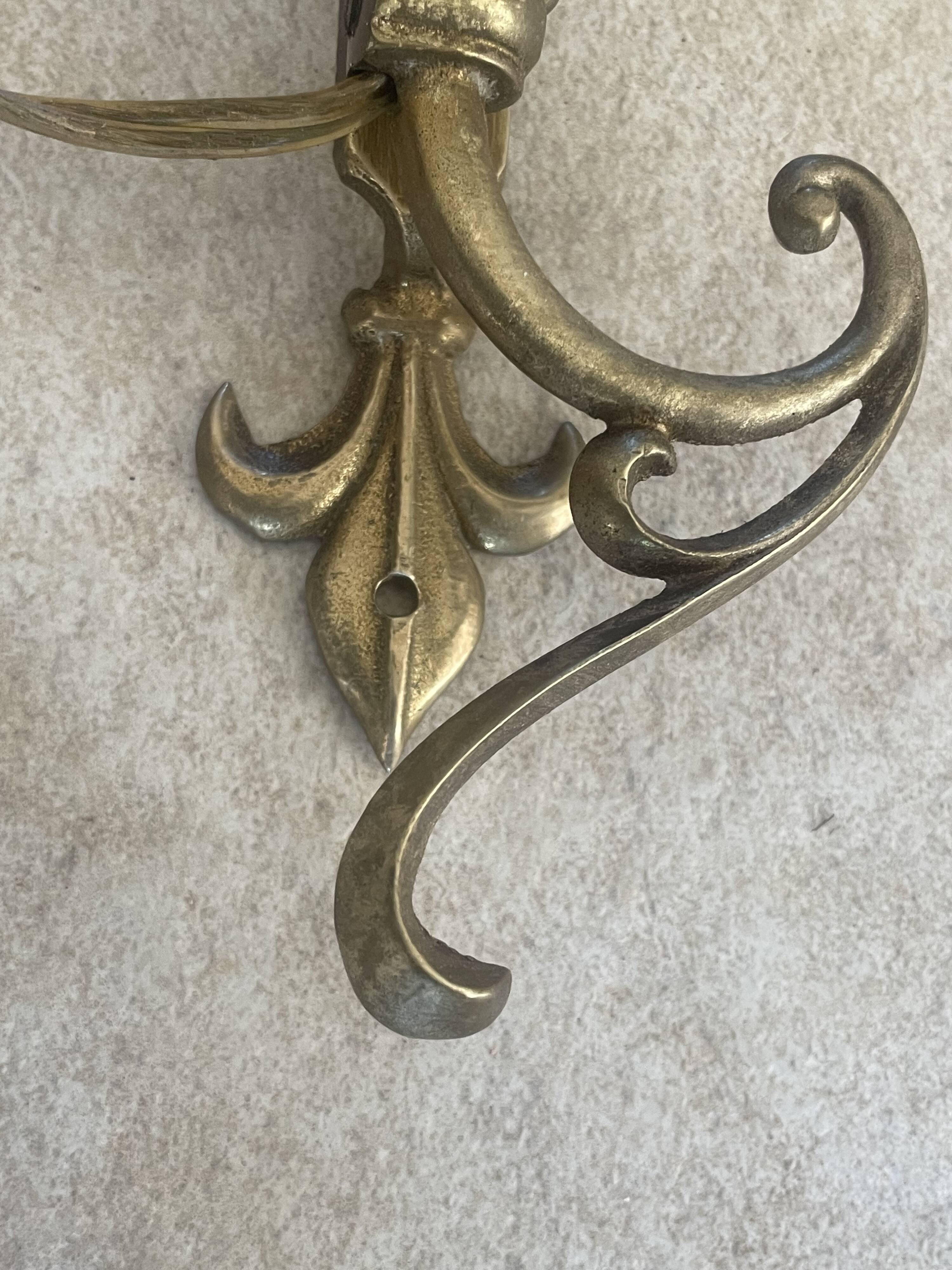 Adjustable wall light in brass and gold metal.