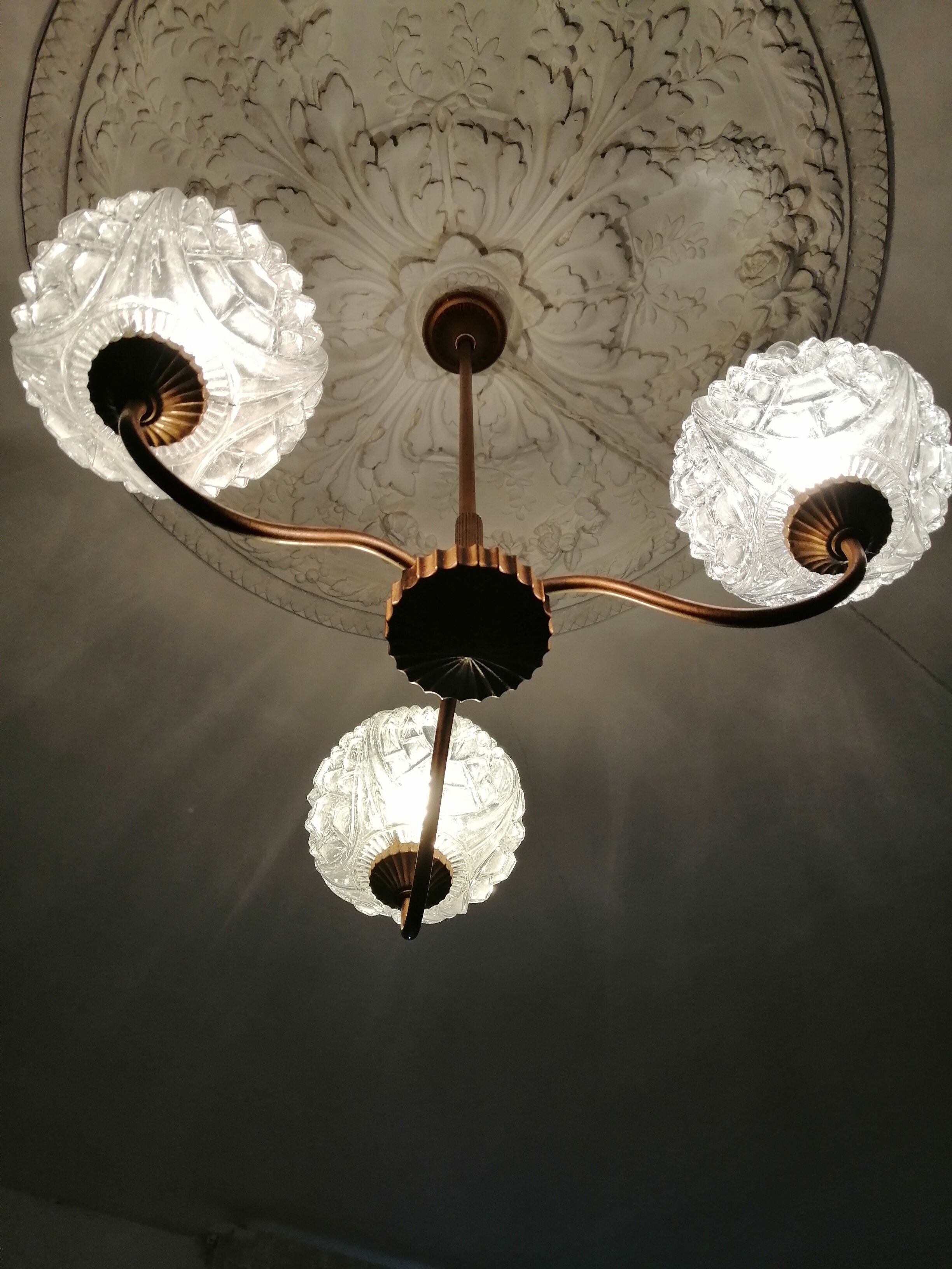 antique chandelier has 3 globes