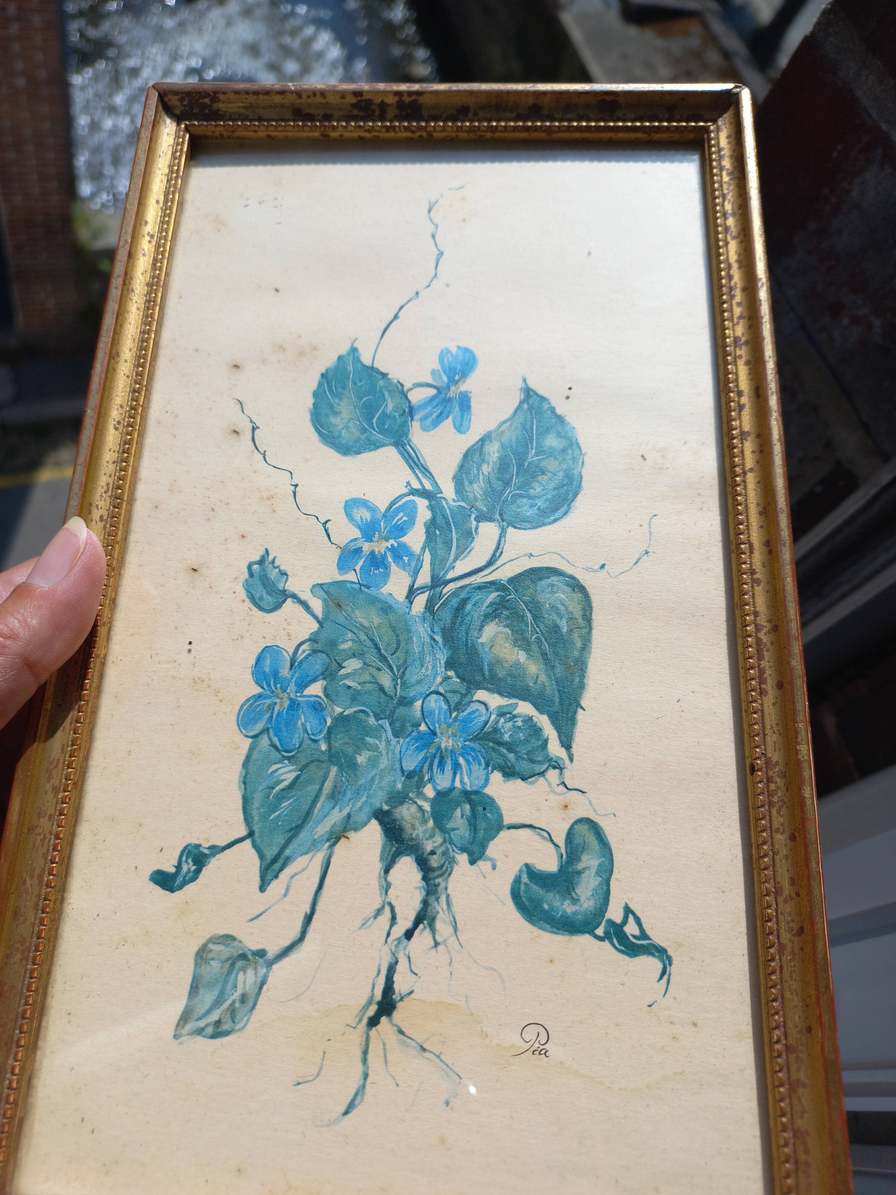 Decorative table with vintage blue flowers in a golden frame.