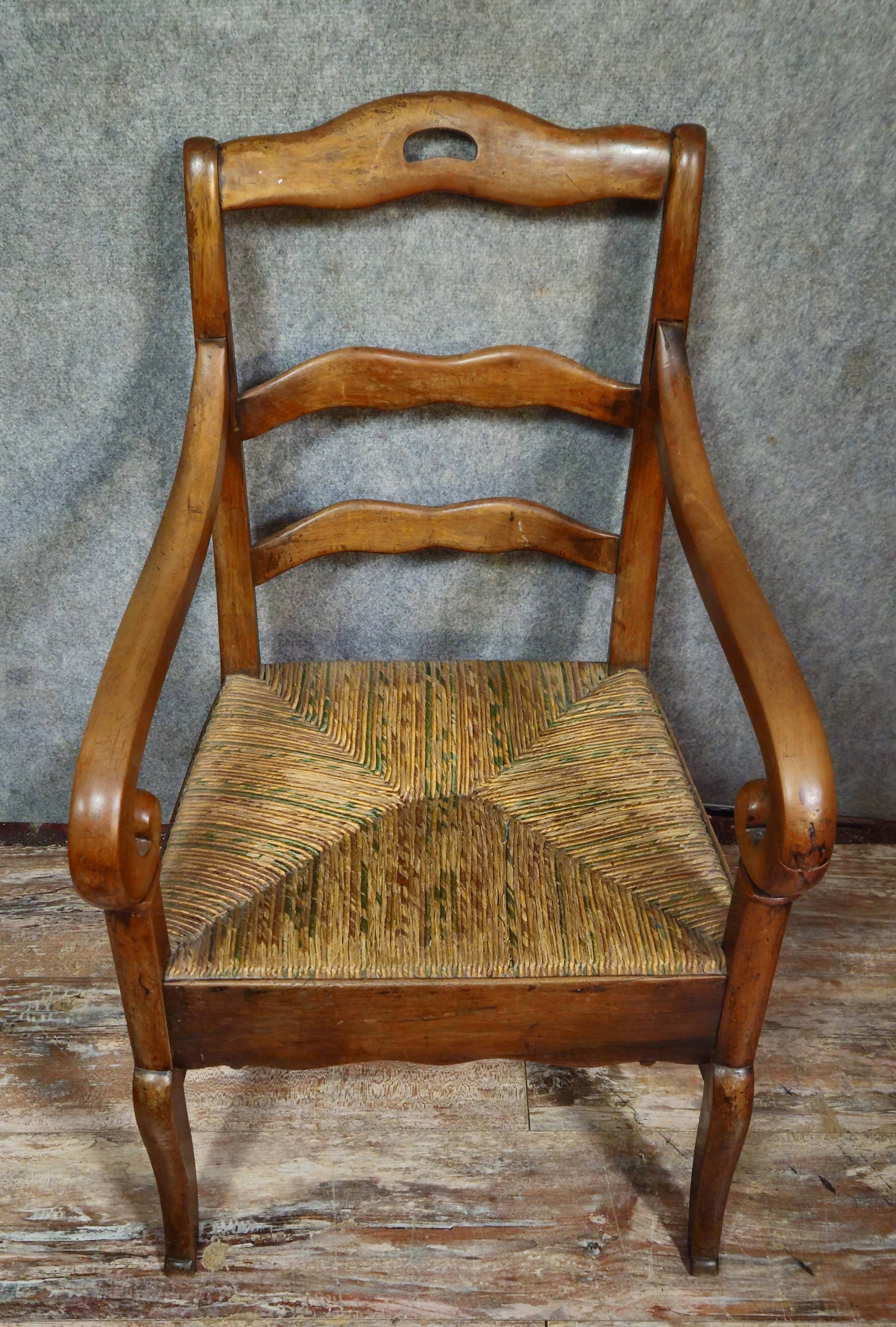 Empire armchair in solid walnut with woven straw seat.