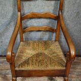 Empire armchair in solid walnut with woven straw seat.
