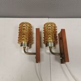 A set of wall lamps in teak wood, with amber colored glass