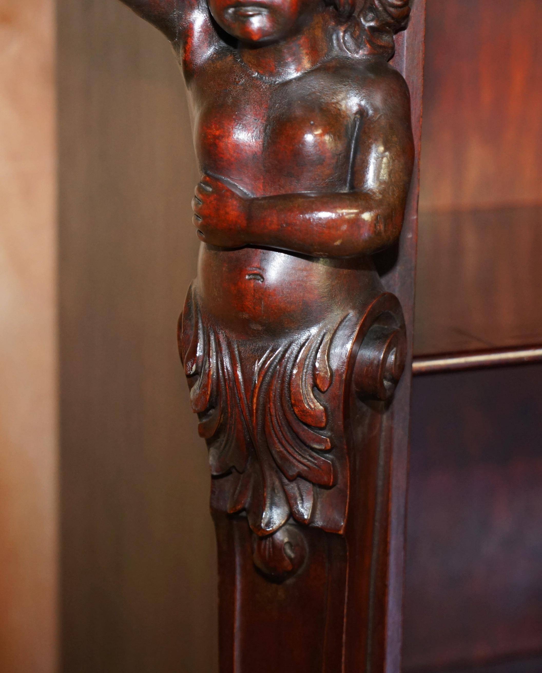Hand-carved library circa 1900 in hardwood with Hermes statues.