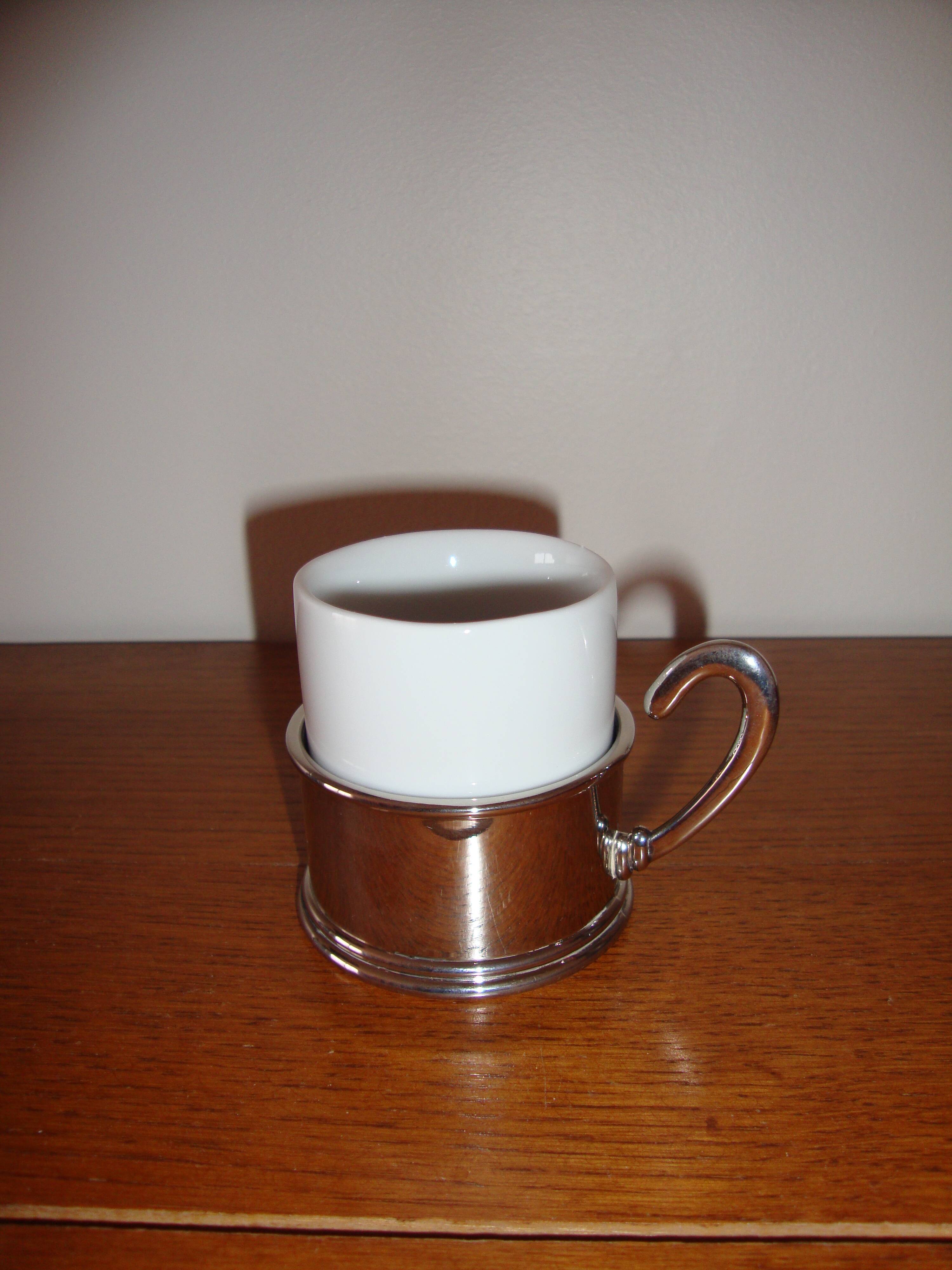 Duo of white ceramic coffee cups metal support