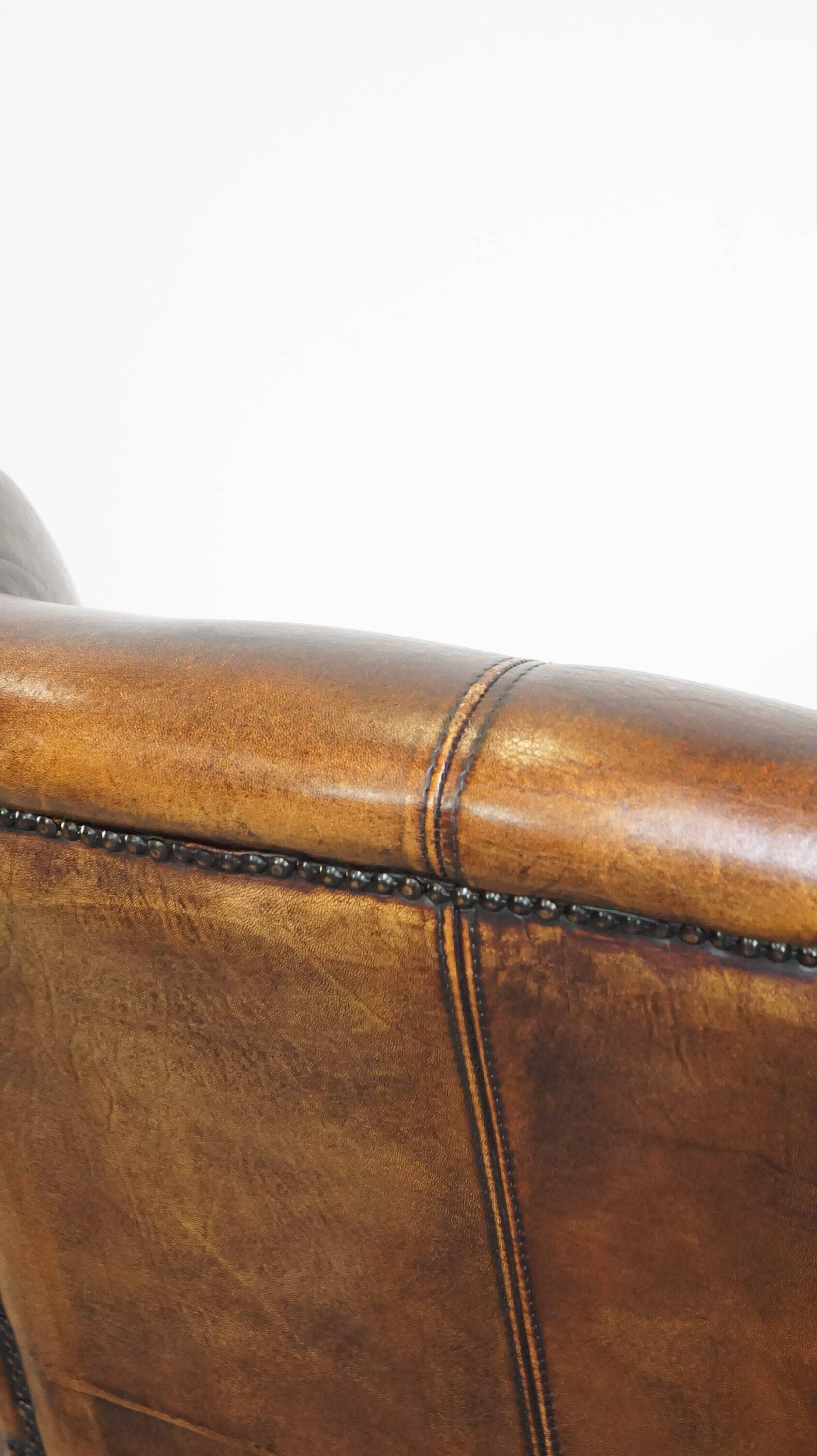 Fauteuil à oreilles confortable et bien entretenu en cuir de mouton