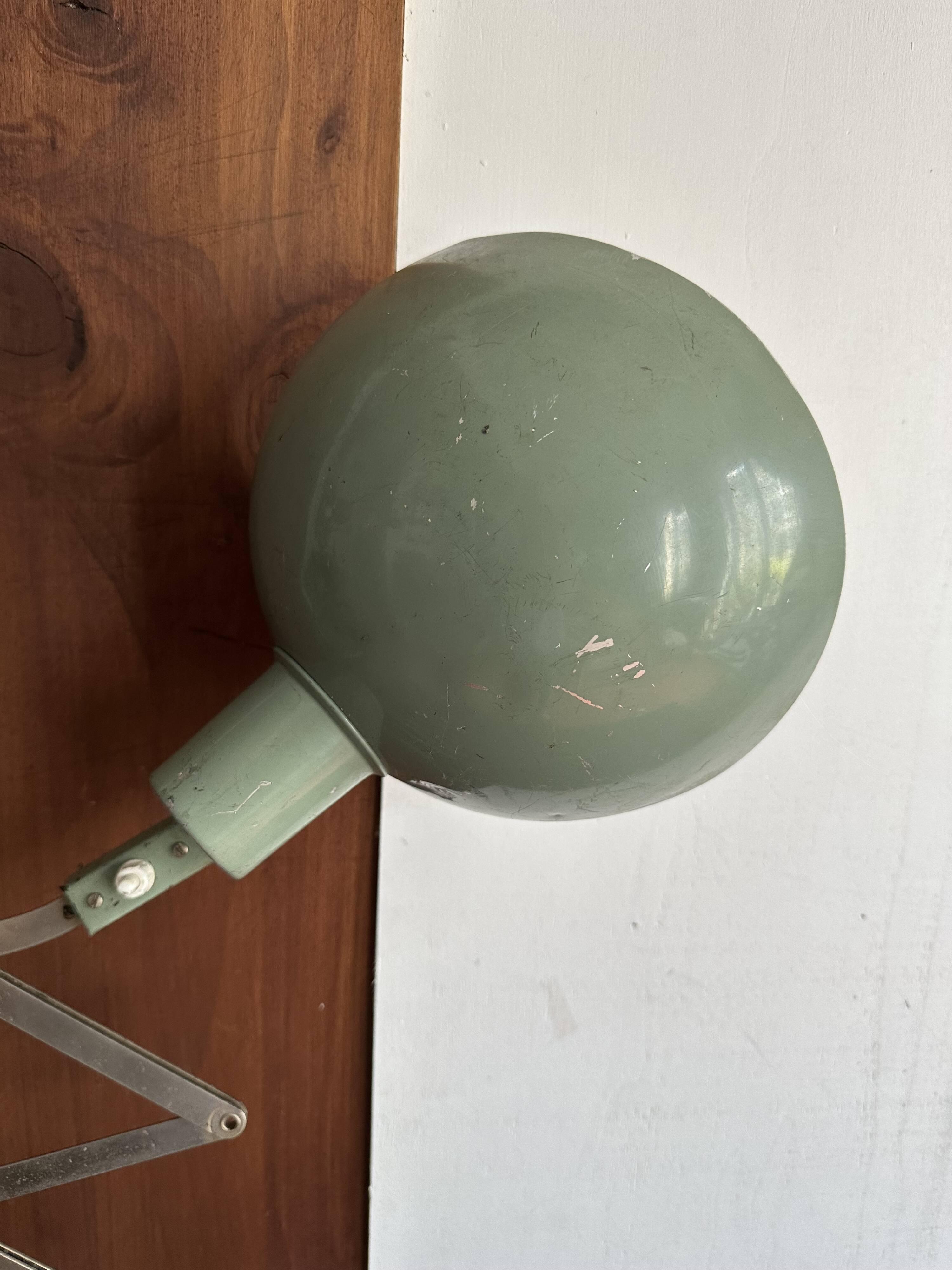 Old extendable accordion lamp in celadon green, workshop spirit.