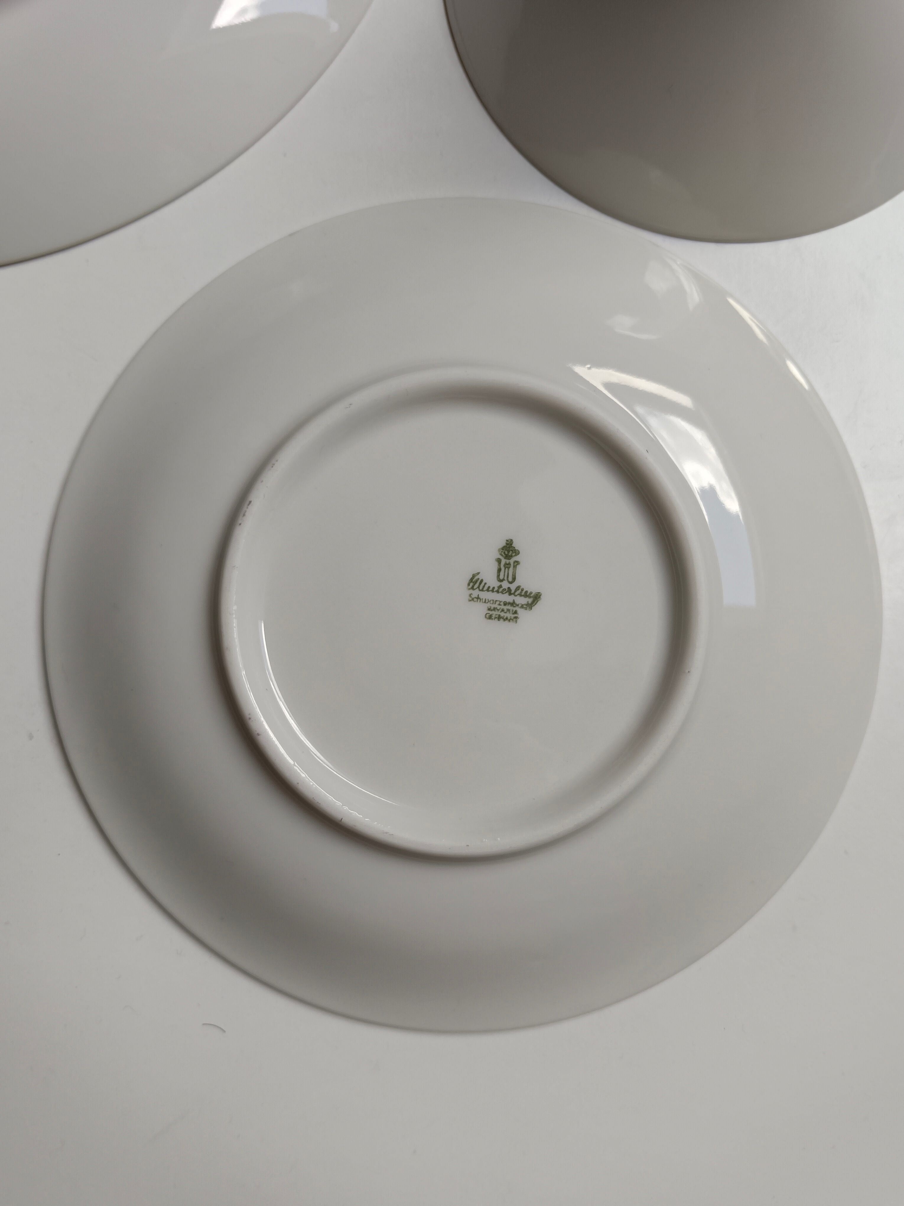 Solitaire tea cup, saucer, and dessert plate in white and gold.