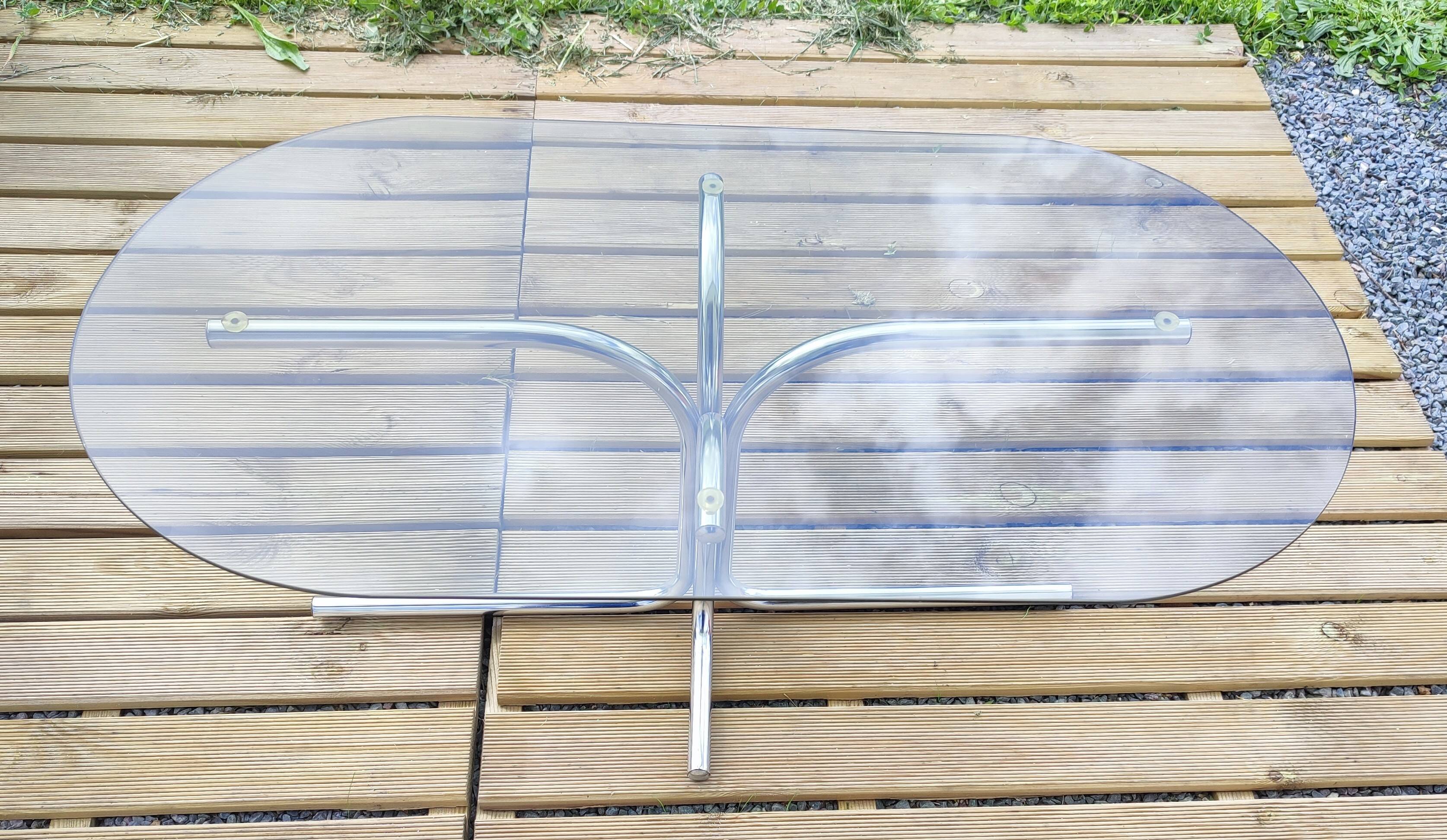 Vintage coffee table with metal tube structure and glass top.
