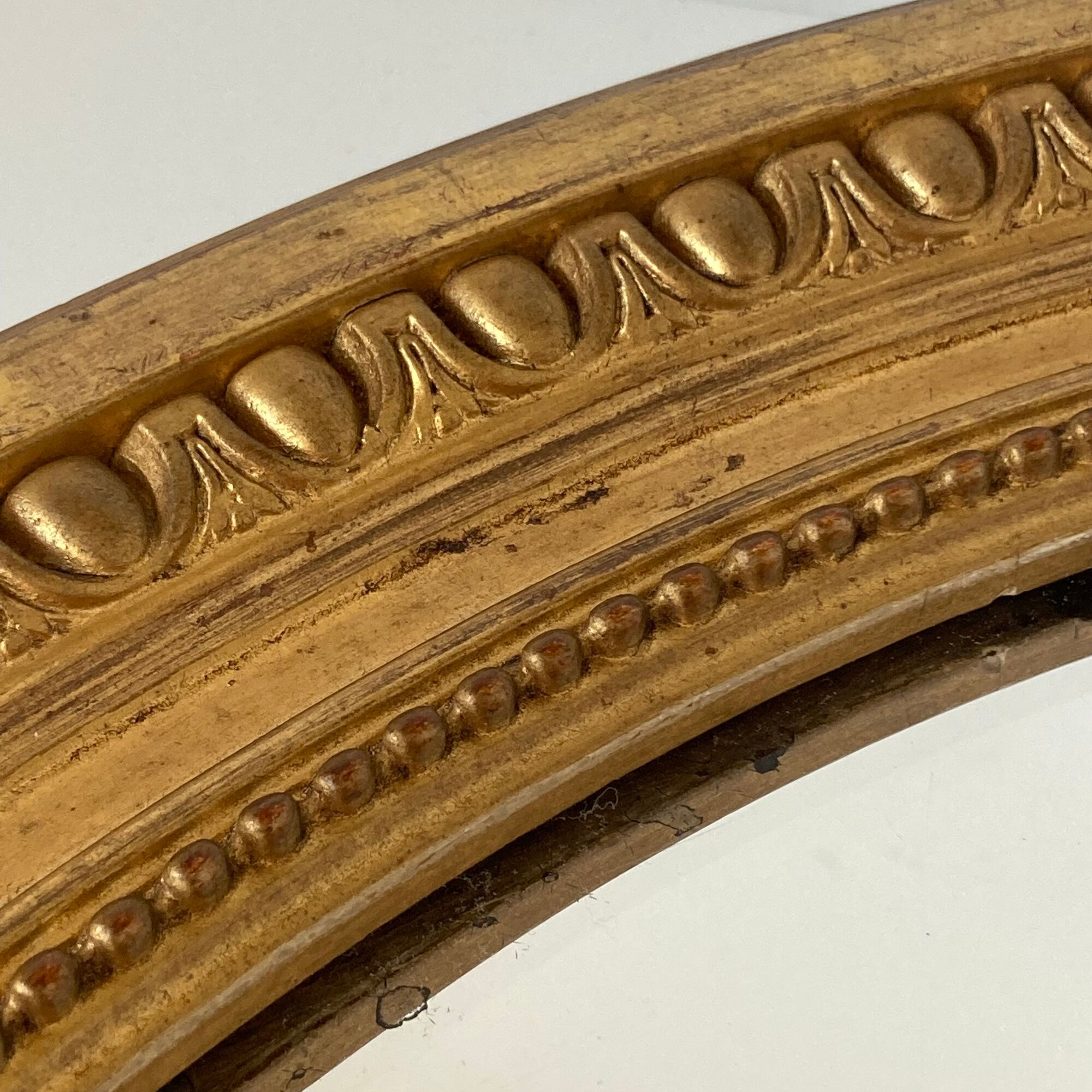 Oval mirror in carved wood, stuccoed and gilded with leaf Louis XVI style late nineteenth century