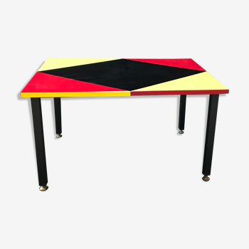 Table basse pieds métal, revêtement formica, design géométique noir rouge et jaune