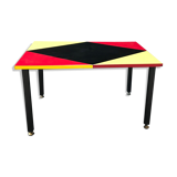 Table basse pieds métal, revêtement formica, design géométique noir rouge et jaune