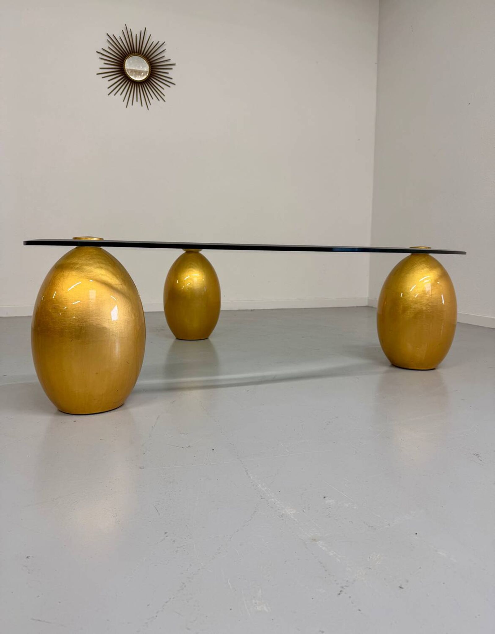 Vintage Italian design coffee table with a glass top and gold base, dating from the 1980s.
