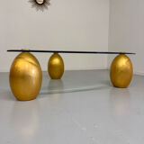 Vintage Italian design coffee table with a glass top and gold base, dating from the 1980s.