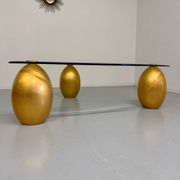 Vintage Italian design coffee table with a glass top and gold base, dating from the 1980s.