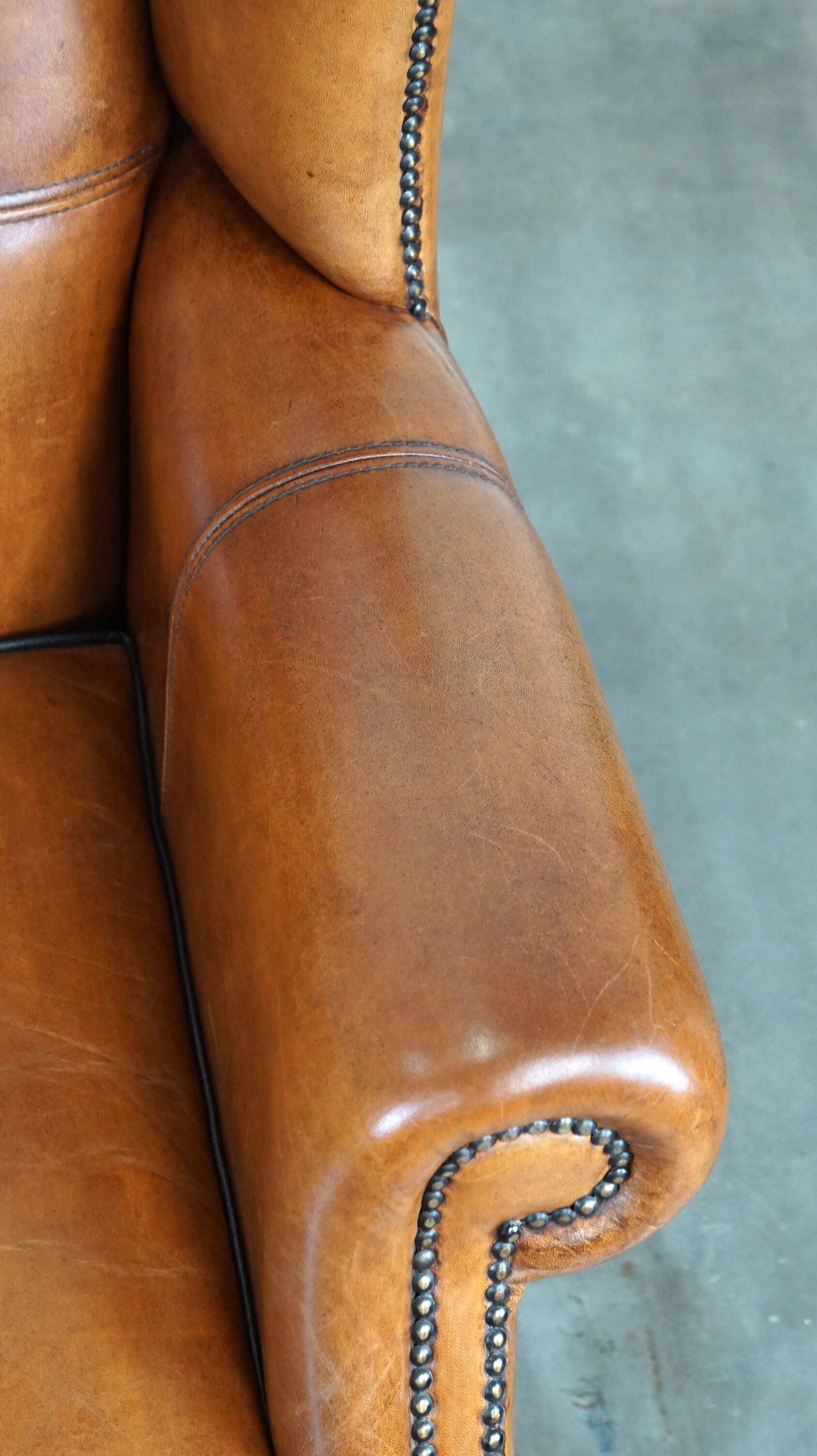 Très beau fauteuil à oreilles en cuir de mouton avec des détails époustouflants