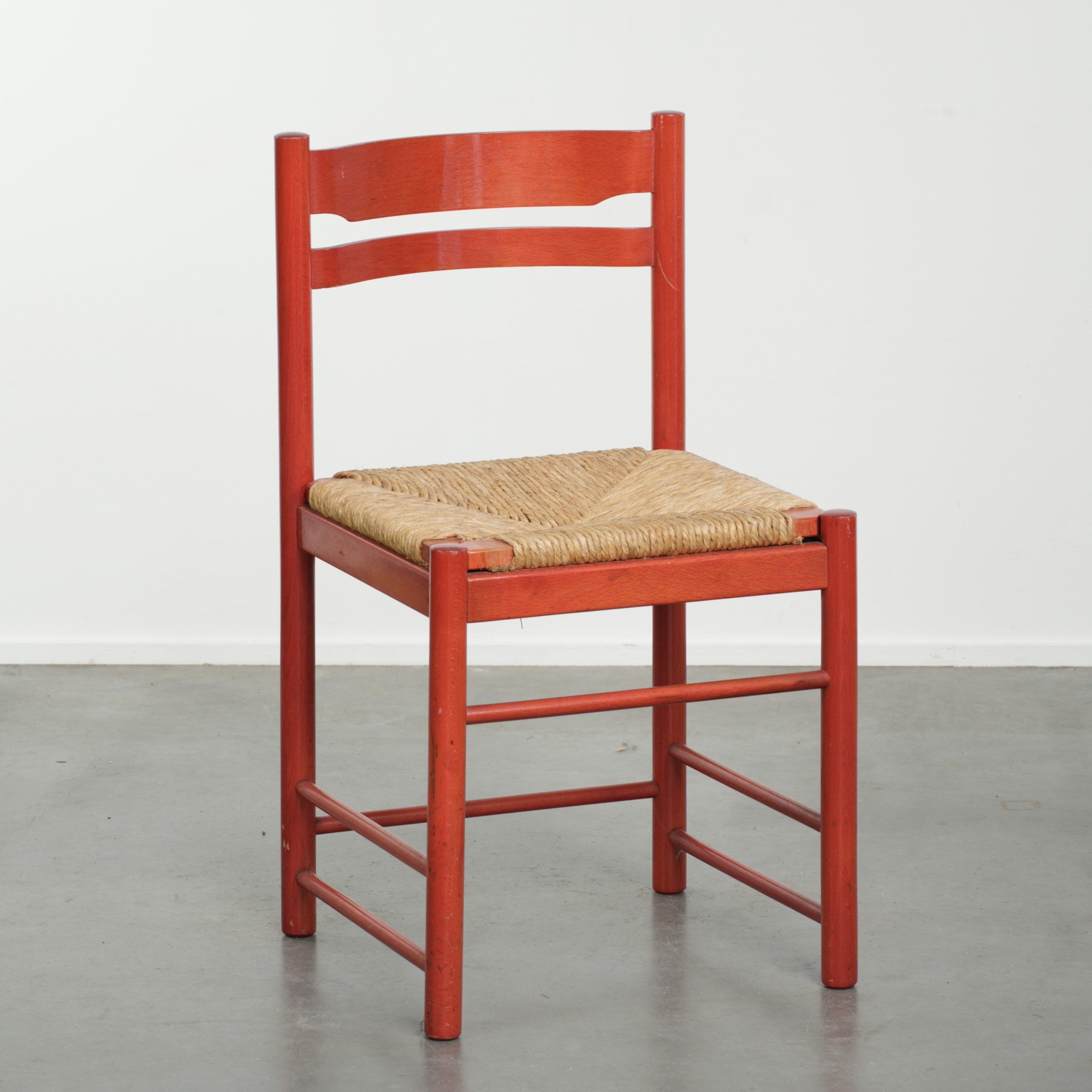 Red vintage wooden chair from the 1970s with a woven wicker seat