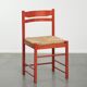 Red vintage wooden chair from the 1970s with a woven wicker seat