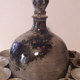 Ceramic liquor service with a decanter and 12 small glasses on tray