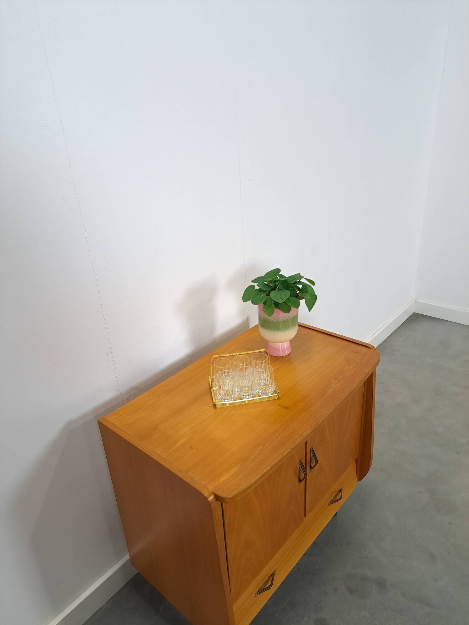 Meuble TV audio avec poignées en laiton et pieds inclinés.