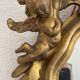 Antique rococo mirror with putti, gilded carved wood and stucco frame, 19th century.