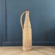 Amber glass bottle in its wicker handle basket.