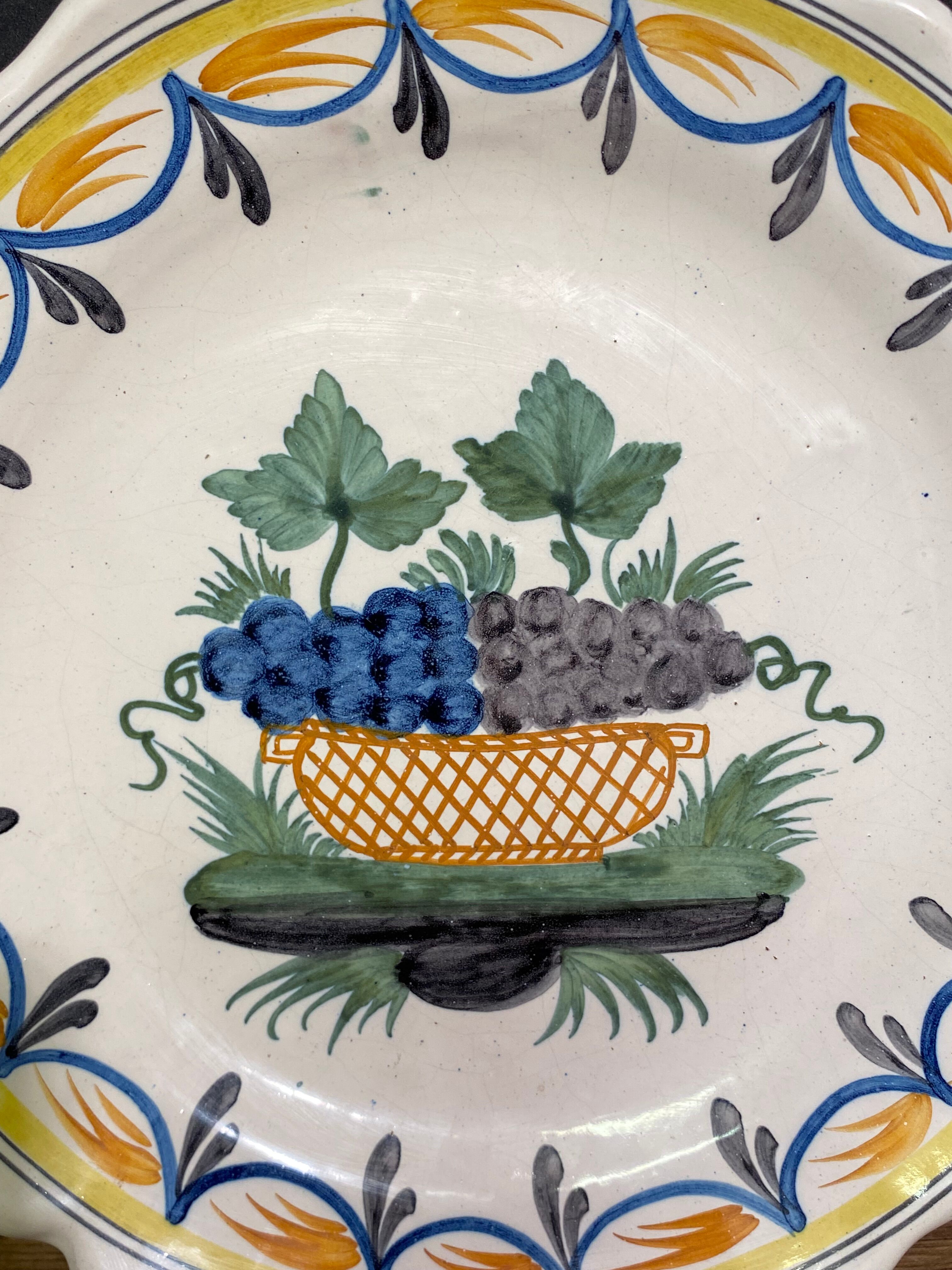 Faience dish of eighteenth-century style nevers decorated with basket with bunches of grapes