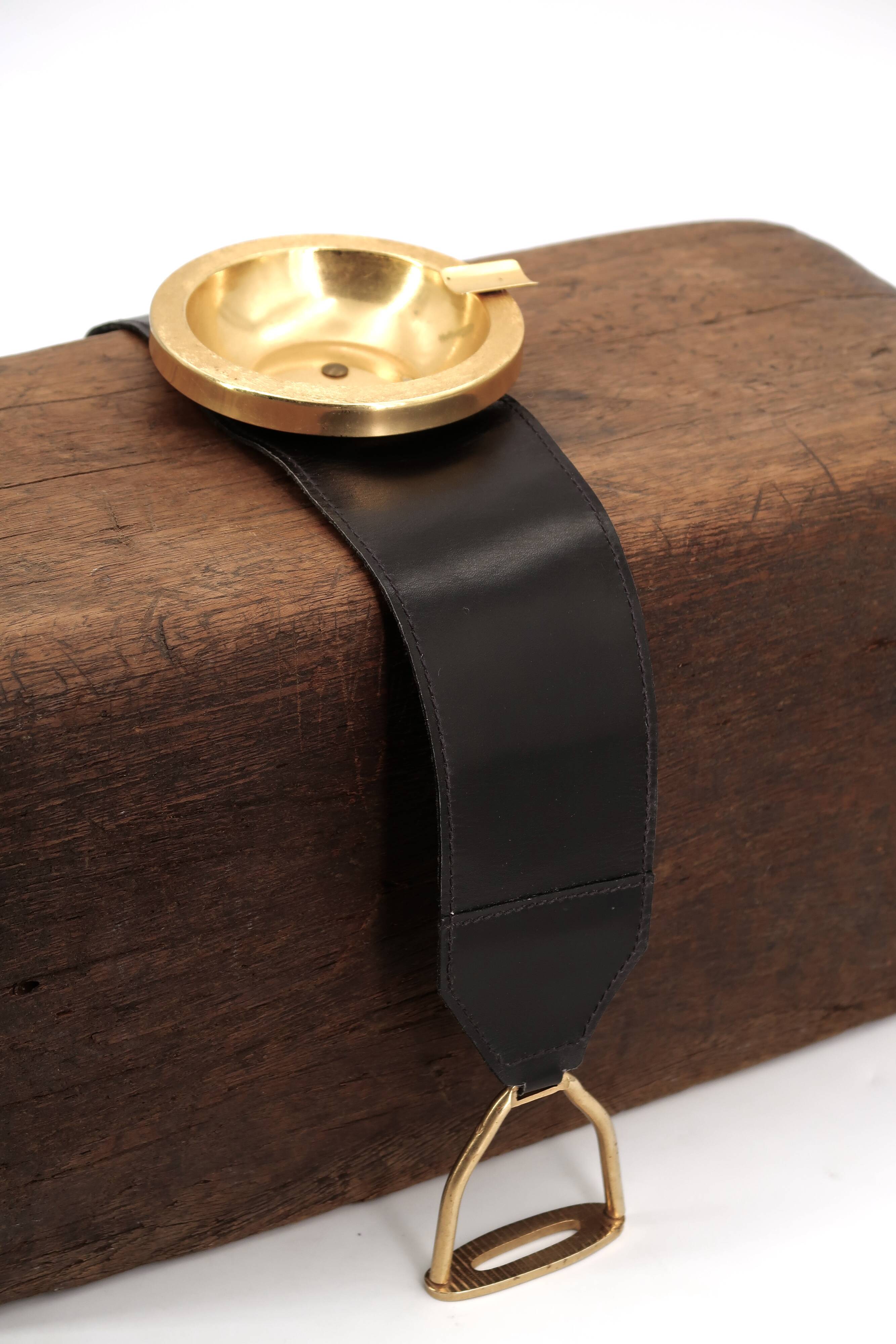 Golden metal armrest ashtray with faux leather and stirrups, 1950s.