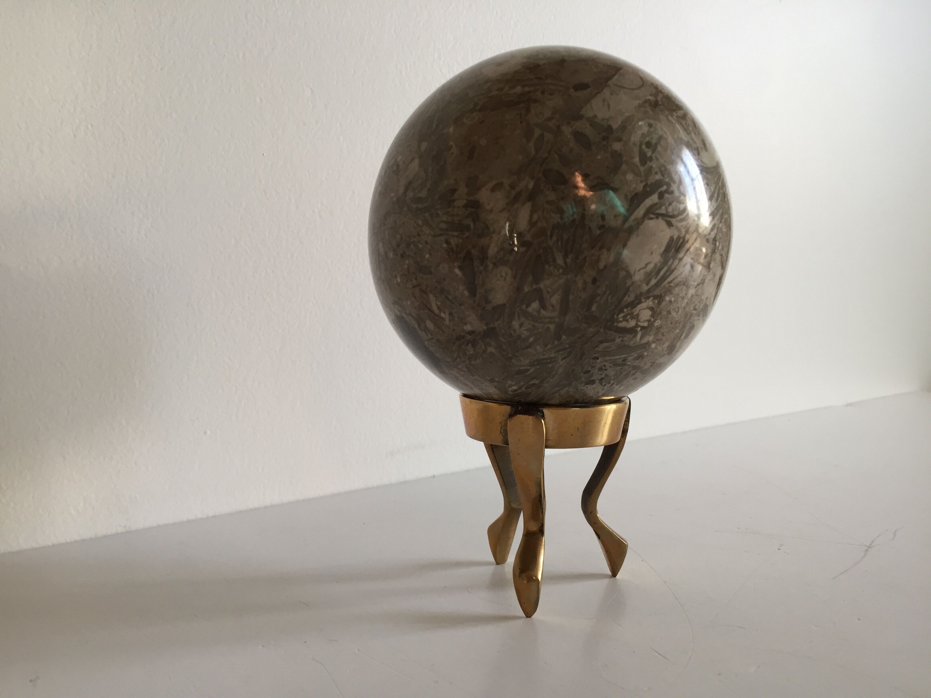 Marble ball paperweight on vintage brass