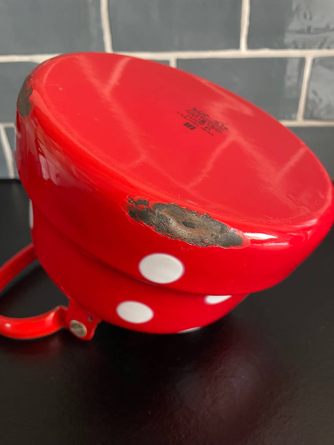 Red enameled sheet metal kettle with white polka dots