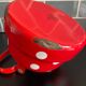 Red enameled sheet metal kettle with white polka dots