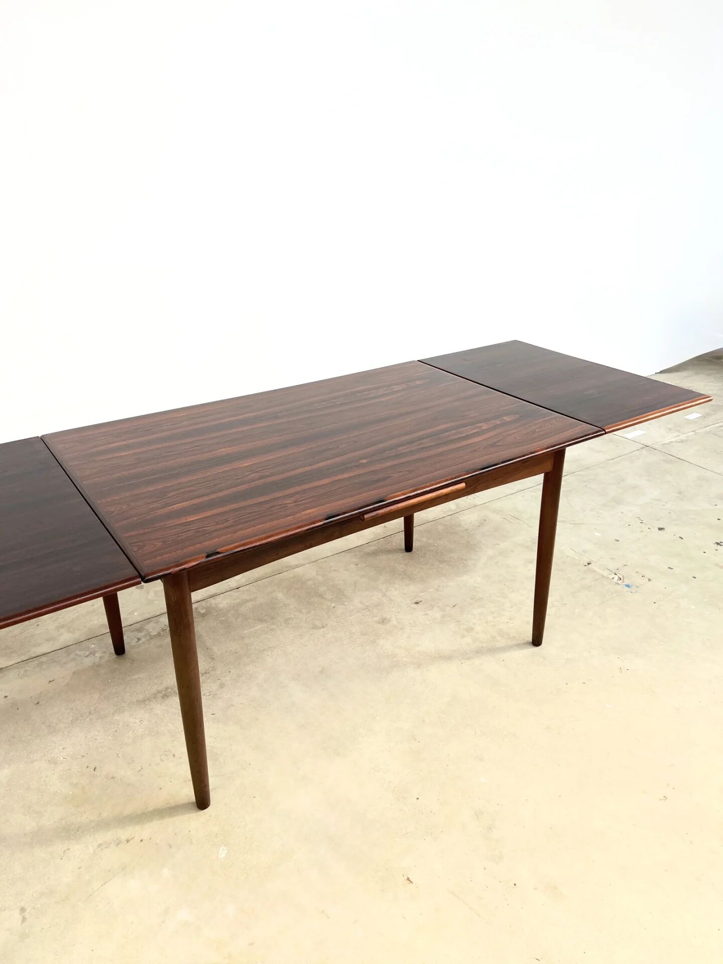 Rosewood dining table with integrated extensions — Denmark, 1960s
