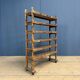 Old wooden workshop shelf with cast iron wheels.