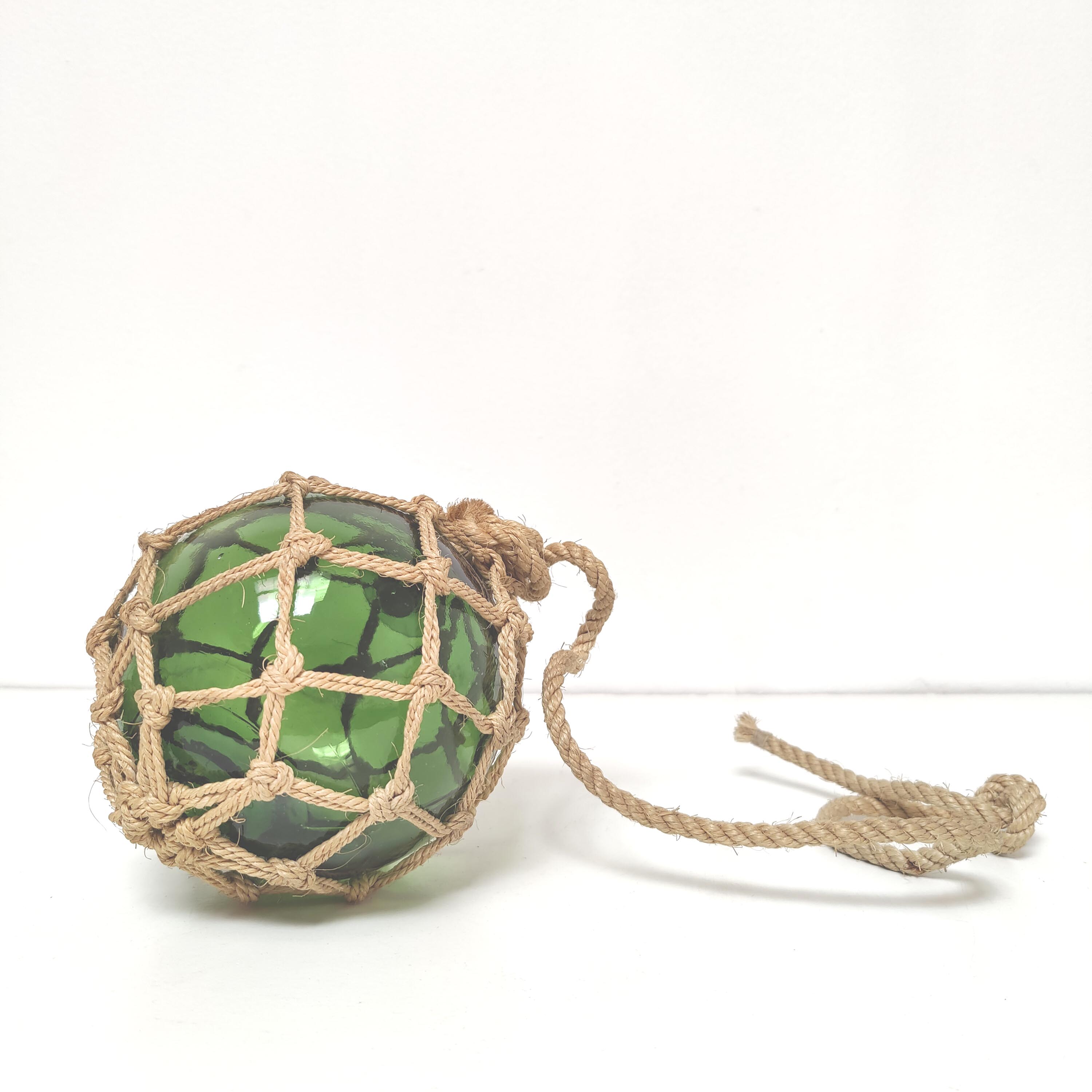 Green ball marine float in glass and rope