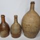 Set of three old enamelled terracotta bottles, 33 cm
