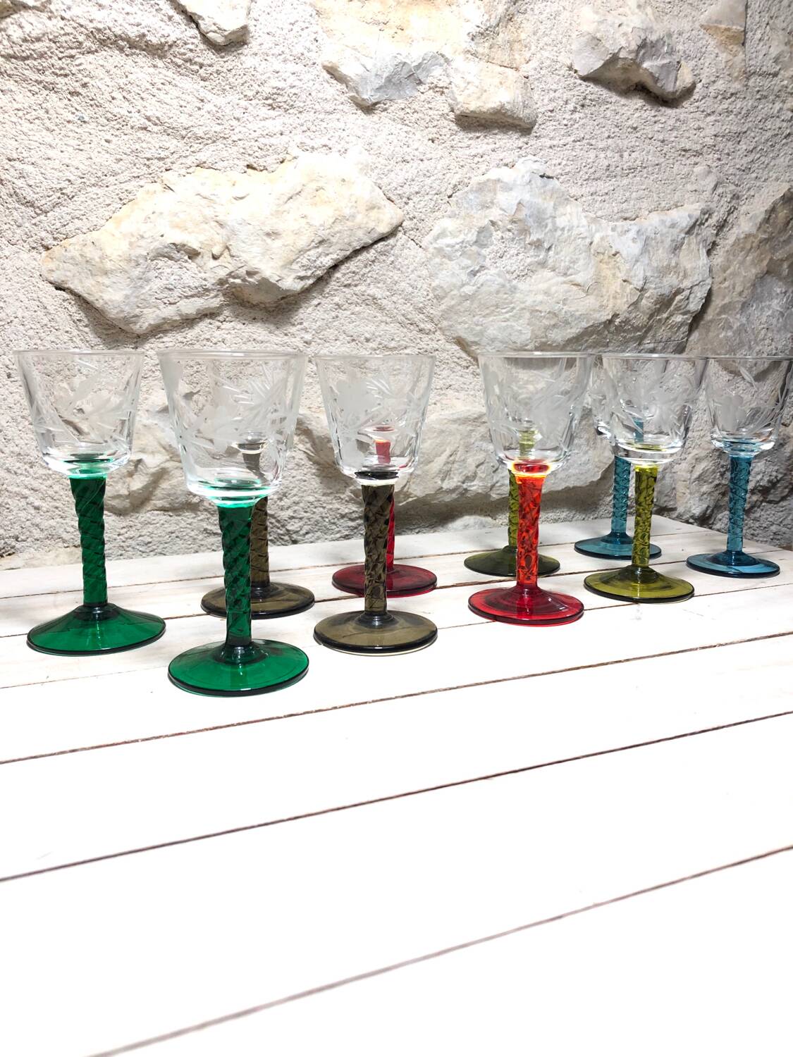 Antique and rare! Sold in a set of 12 colorful twisted stemmed glasses engraved with flowers and leaves