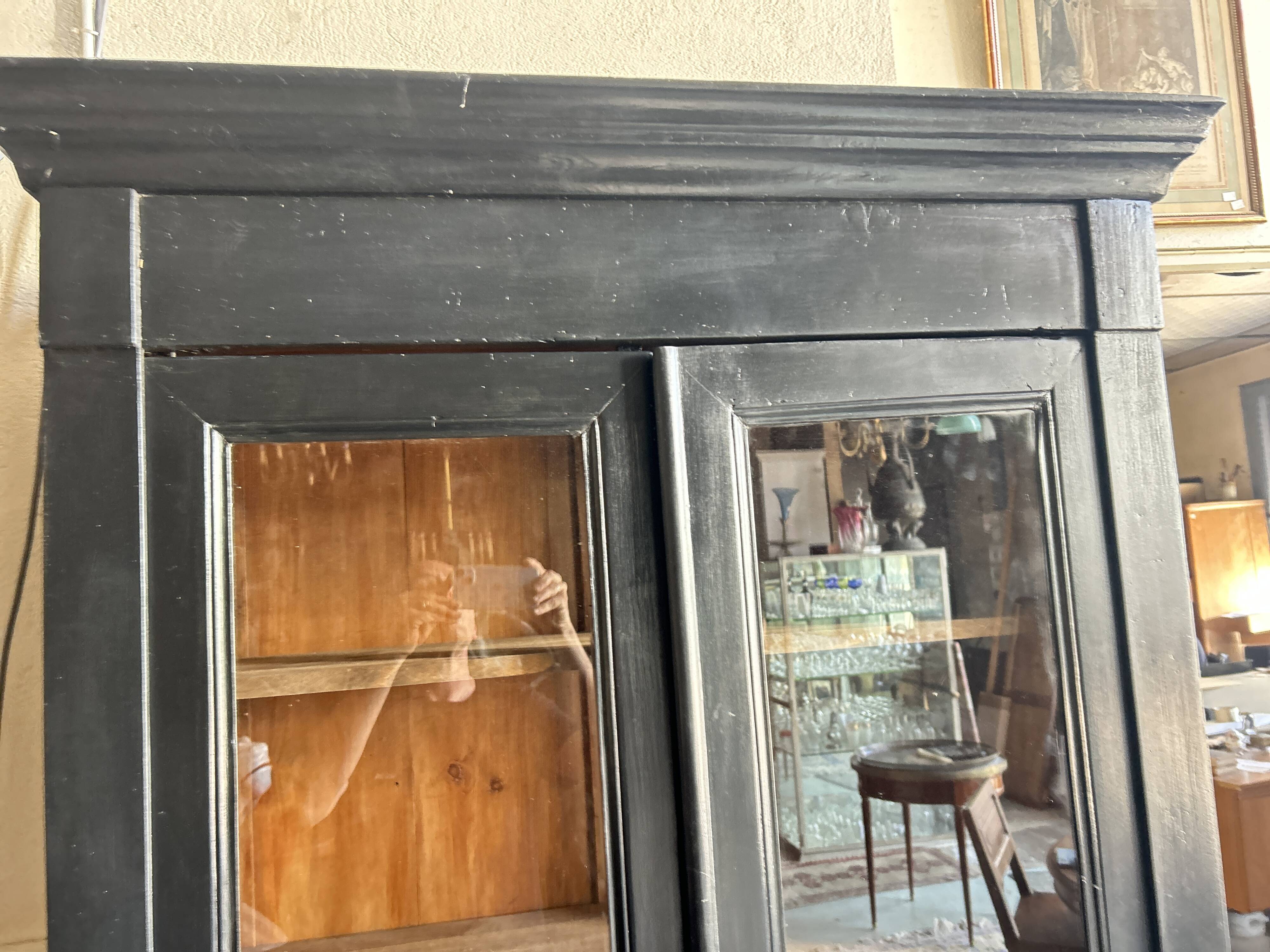 Black painted wardrobe with two glass doors and an interior sideboard.