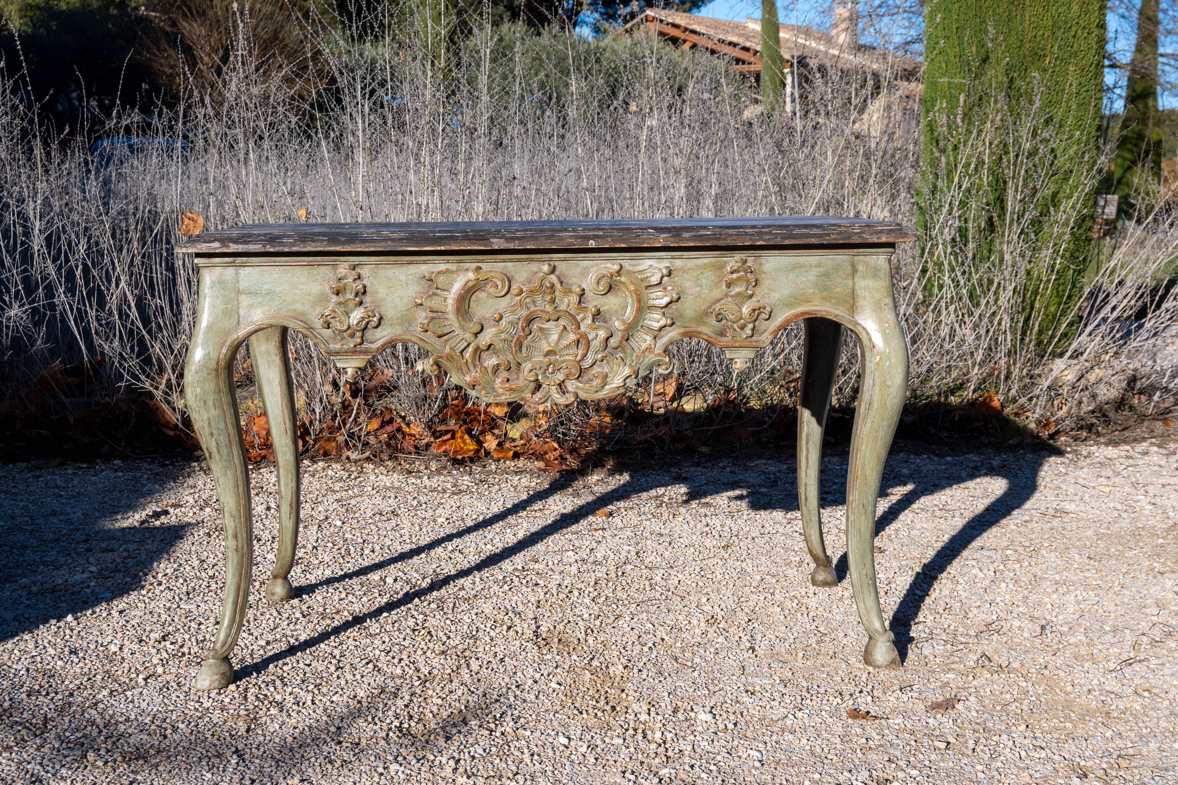 Console in patinated gray-green lacquered wood, molded and sculpted. Arched base on hooves.