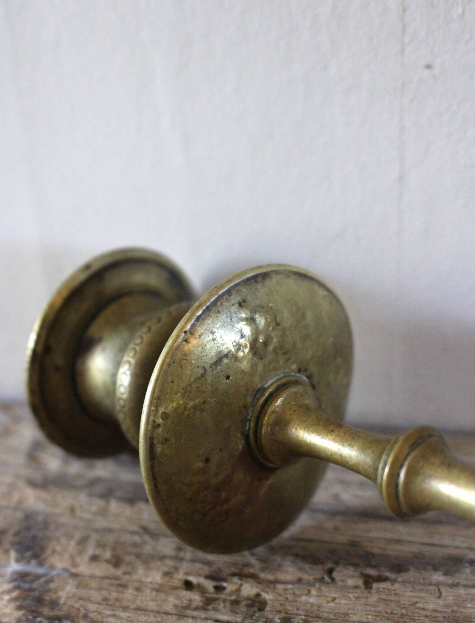 Brass candle holder with flowers and round shape.