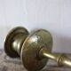 Brass candle holder with flowers and round shape.