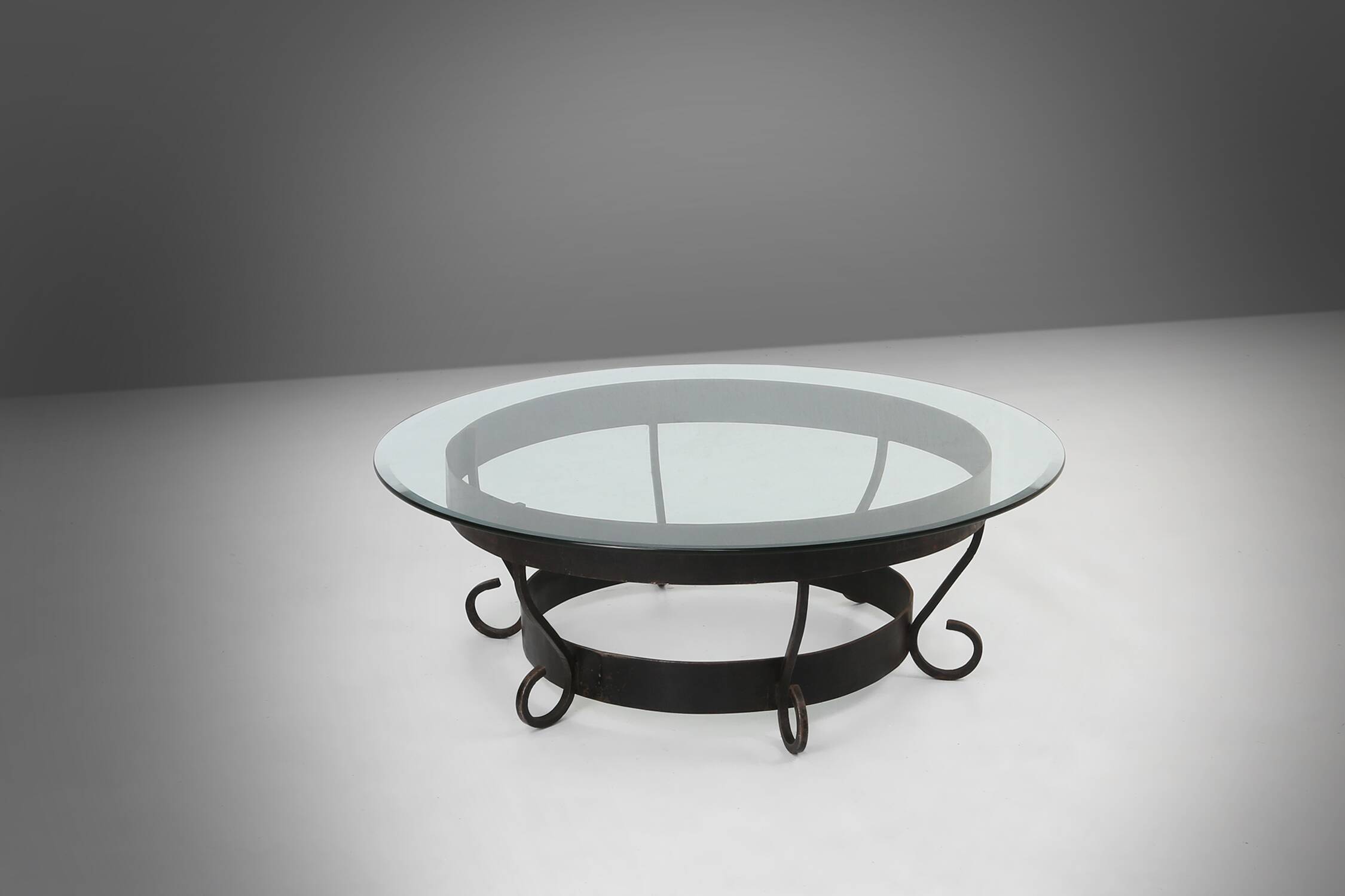 Rustic round coffee table with wrought iron base and glass top, France, 1930s