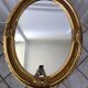 Grand miroir oval en stuc doré vintage
